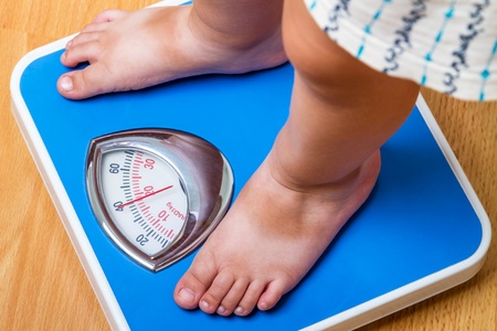 Closeup view of scales on a floor and kids feetの写真素材