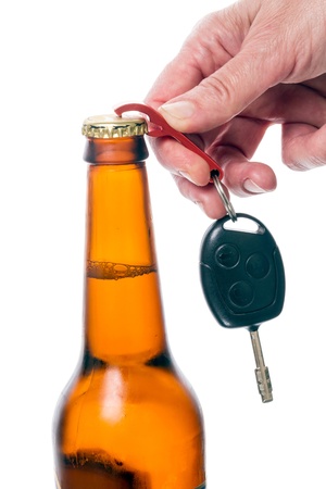 Hand opens a bottle of beer keychain car key. Isolated on white backgroundの写真素材