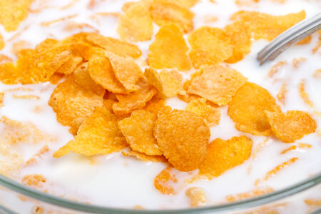 Crispy corn flakes with milk in a spoon  close-upの写真素材