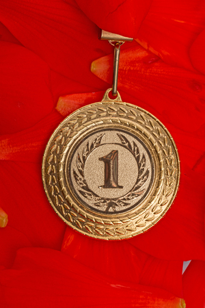 Gold sport medals on red petalsの写真素材