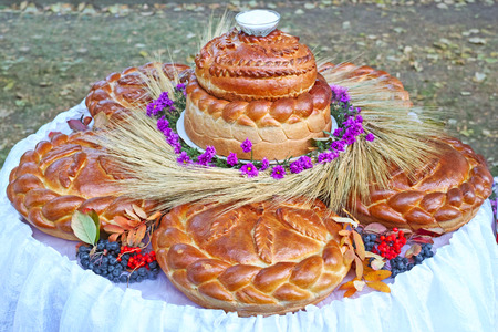 A large loaf of bread and salt decorated with flowers and berriesの写真素材