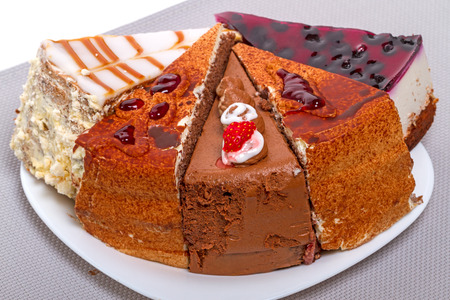 Five different pieces of cake on a white plate