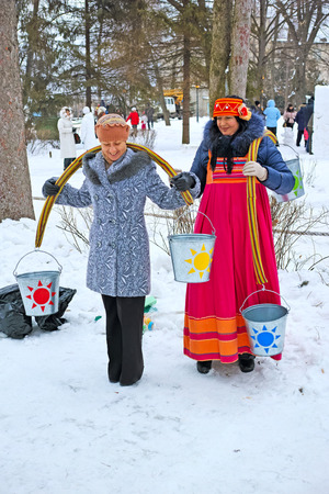 Tambov, Russia - February 15, 2015: Maslenitsa (pancake week, shrovetide) - carnival of farewell winter and meeting spring in Tambov.  Women with rockers carrying buckets of water.  The quality of medium formatのeditorial素材