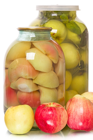 Fresh apples and the glass jars with canned and pickled apples isolated on white backgroundの写真素材