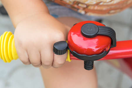Close up of bicycle bell on handlebars and hand the child.の写真素材
