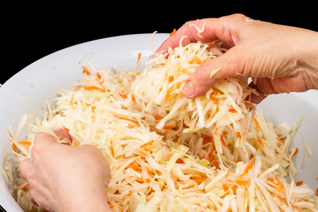 Preparation of sauerkraut in the bowl.  Chopped cabbage with carrotsの写真素材