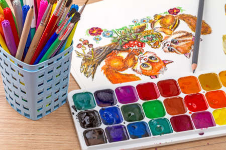 Watercolor painting with two squirrels and equipment for drawingの写真素材