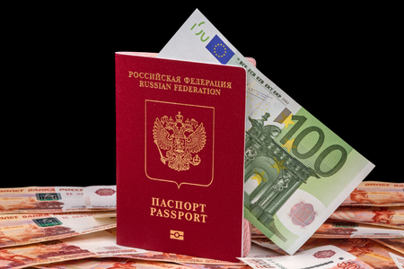 Russian passport for foreign countries and 100 euros isolated on a black backgroundの写真素材