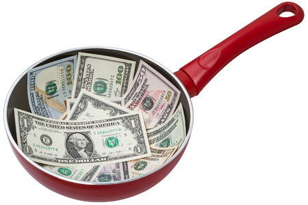 Banknotes of dollars on a frying pan. Isolated on white backgroundの写真素材