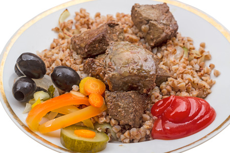 Prepared slices of liver with vegetables, olives, ketchup and garnish buckwheatの写真素材