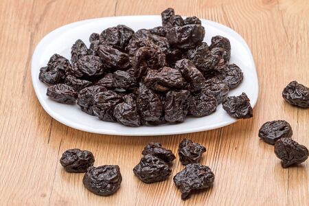 Pile dried pitted prunes on a white plate. Natural Foodsの写真素材