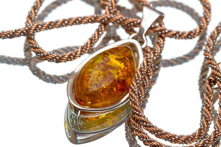 Pendant with amber on a gold chain isolated on white backgroundの写真素材