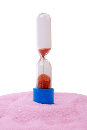 Hourglass on pink sand on white background