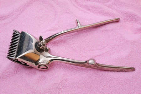 Vintage (1957) manual hair clipper on pink sand