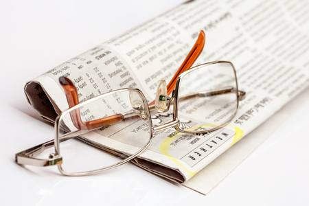 Reading glasses on a folded English newspaperの写真素材