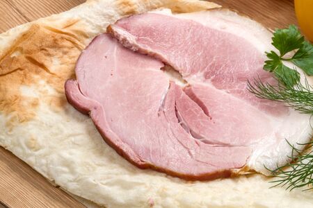 A large piece of Pork loin on pita bread and greensの写真素材