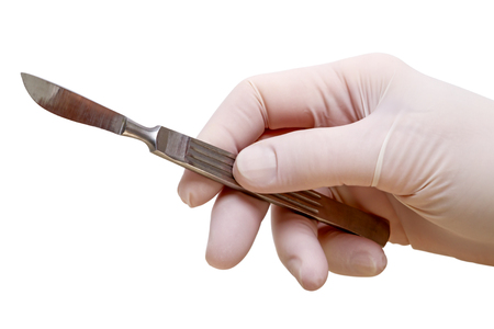 Hand with a surgical scalpel isolated on white backgroundの写真素材