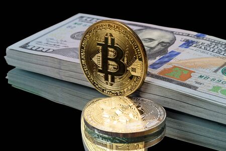 Gold and silver  bitcoin and a pack of dollar on a black backgroundの写真素材