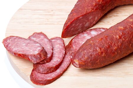 Smoked sausage on a kitchen board.  Isolated on white backgroundの写真素材
