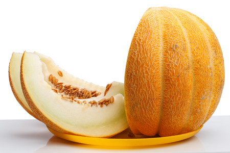 Slices of ripe melon on a yellow plate isolated on a white backgroundの写真素材