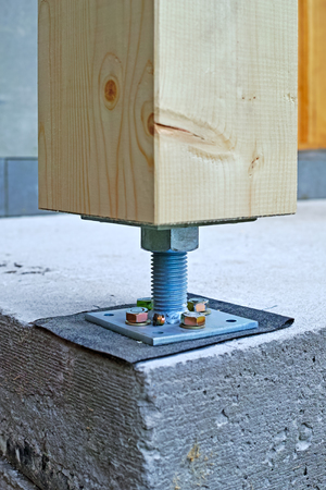 Fastening of a wooden bar to a concrete site by a metal hairpinの写真素材