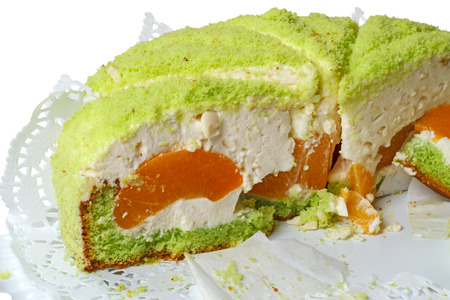 Half of big cake with peaches on white backgroundの写真素材