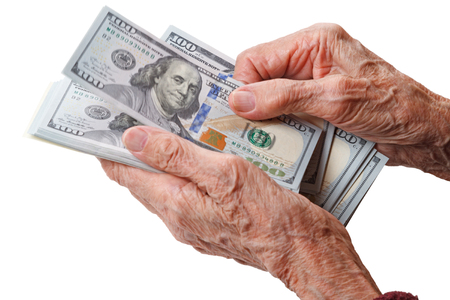 Wrinkled hands of an old woman counts one hundred dollar billsの写真素材