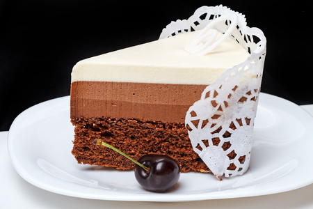 Piece of cake and cherry isolated on black backgroundの写真素材