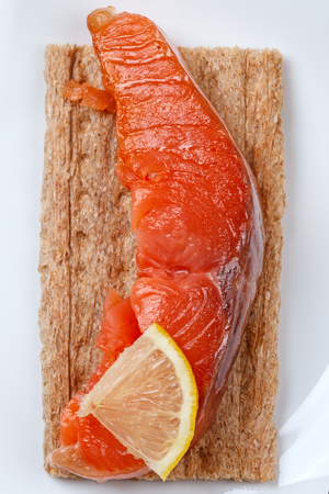 A piece of smoked Far Eastern salmon on a rye galeの写真素材
