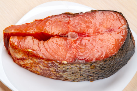 A piece of smoked Far Eastern salmon on a white plateの写真素材