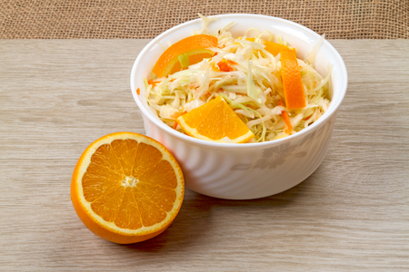 Bowl with sauerkraut and fresh orange on the tableの写真素材