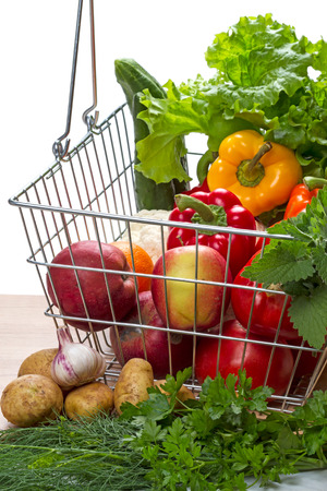 Shopping basket with vegetables and fruits on white backgroundの写真素材