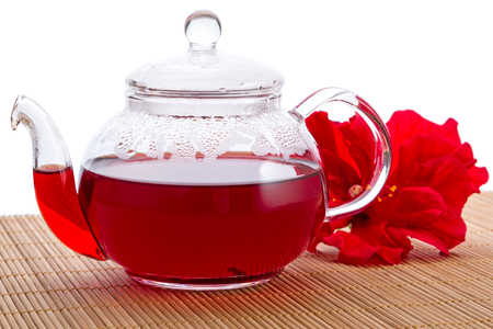 Transparent teapot with hot tea and hibiscus flowerの写真素材