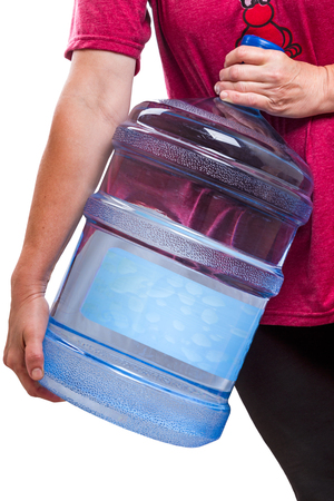 Woman carries a large bottle drinking water 20 litersの写真素材