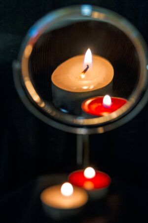 The reflection in the mirror with the rise of two burning candlesの写真素材