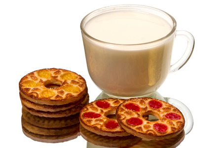 Round cookies and a transparent cup of milk on a mirror isolated on white backgroundの写真素材
