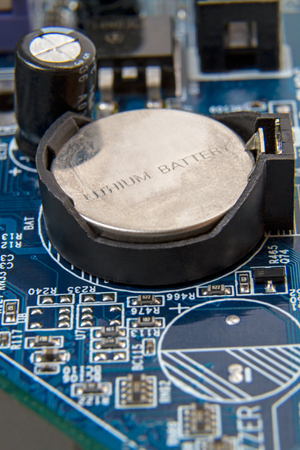 Old Lithium battery on the computer motherboardの写真素材