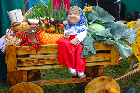 Grandma doll on a wooden cart with a harvest of vegetablesの写真素材