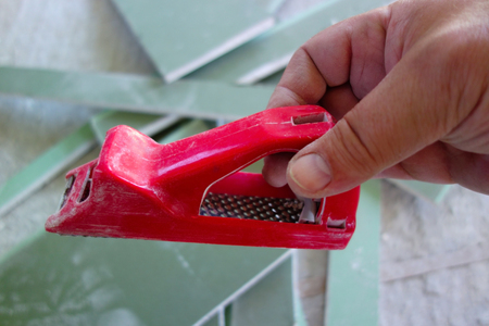 Hand with a plane for work with gypsum cardboardの写真素材