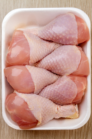 Raw halal chicken legs in the package on the tableの写真素材