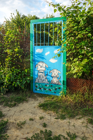 Metal door with the image of two dogs at the entrance to the gardenのeditorial素材