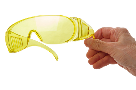 Hand with plastic safety glasses isolated on white backgroundの写真素材