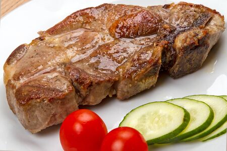 Big piece of fried meat with vegetables on a white plateの写真素材