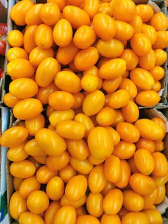 Yellow tomatoes in a box in the supermarket. Nature backgroundの写真素材
