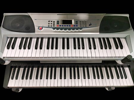 Two keyboard digital music instruments on black backgroundの写真素材