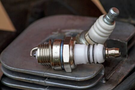 A spark plug ( a sparking plug) is a device for delivering electric current from an ignition system to the combustion chamber of a spark-ignition engine to ignite the compressed fuel/air mixture by an electric spark, while containing combustion pressure within the engine. の写真素材