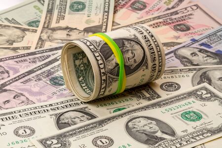 Rolled up money with elastic on dollars backgroundの写真素材