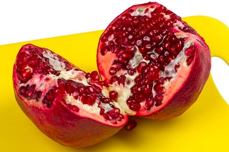 Two halves of a pomegranate on the kitchen boardの写真素材