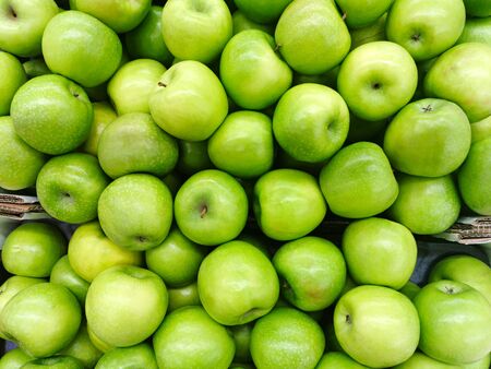 Background of green apples in a cardboard boxの写真素材