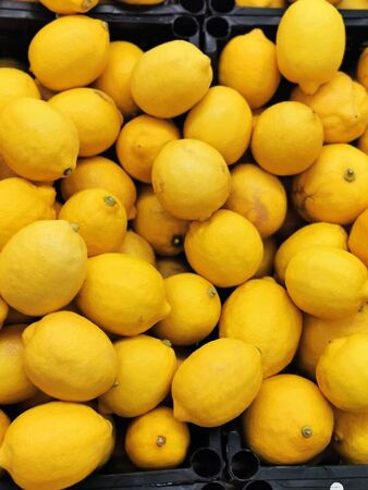 Background of ripe yellow lemons in black boxesの写真素材